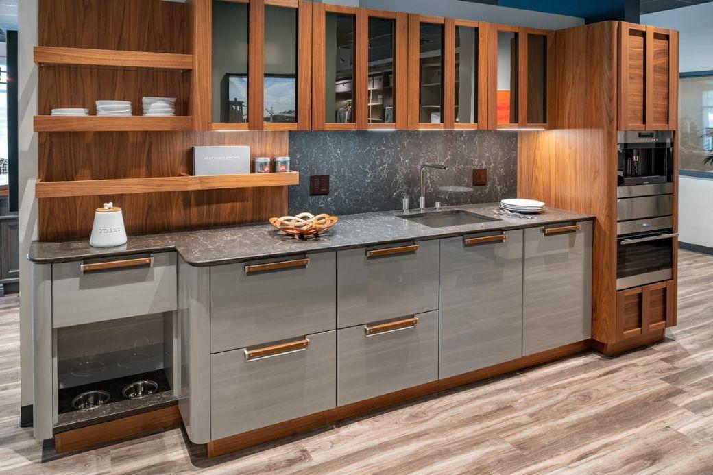 Third view of a sample kitchen by Interiology, featuring warm wooden tones and marble grays with a unique hidden dog bowl.